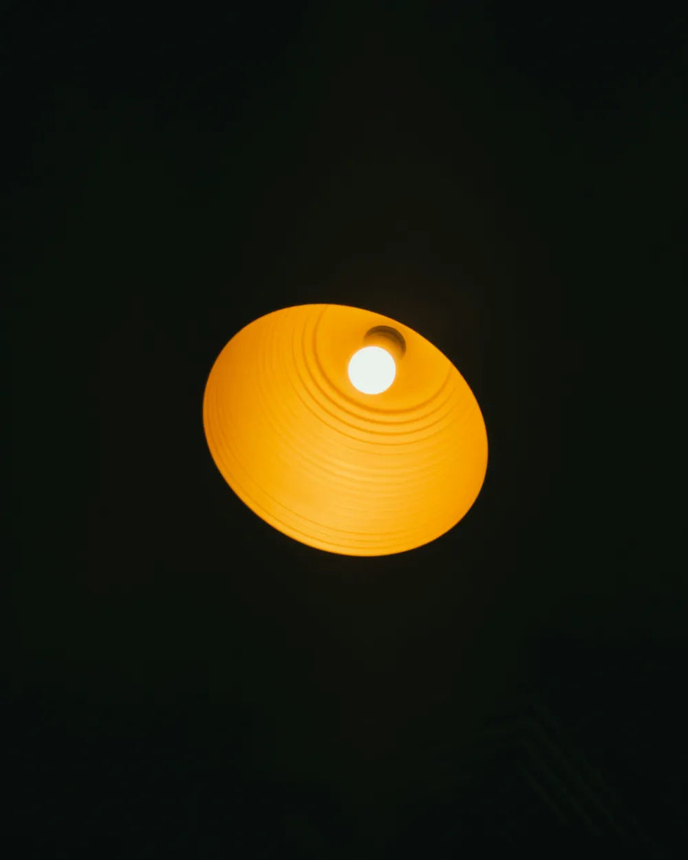 Amber sleep bulb glowing warm orange against a dark background