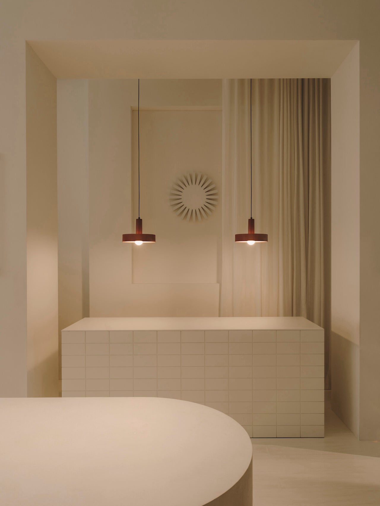 Modern bathroom interior with a bathtub, pendant lights, and decorative wall art.