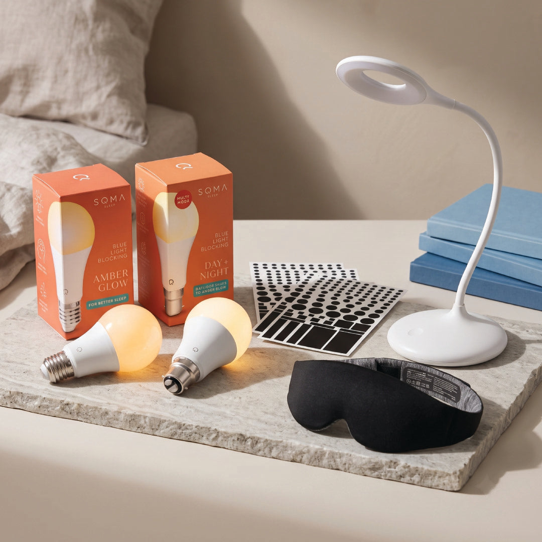 lamp, sleep mask, light bulbs and stickers on bedside table.